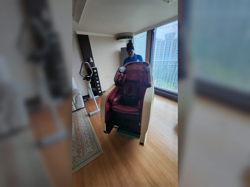 작업자가 안마의자를 이동시키는 모습
