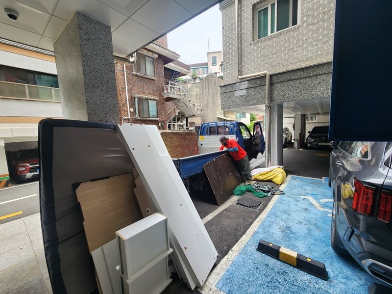 트럭에 적재 중인 침대 매트리스와 프레임 부품