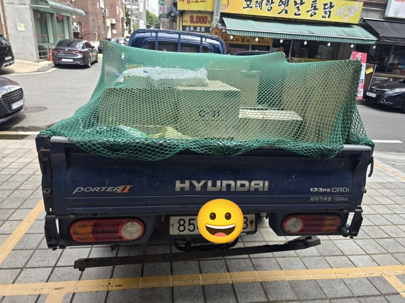 폐기물이 트럭 적재함에 실려 그물망에 덮인 모습