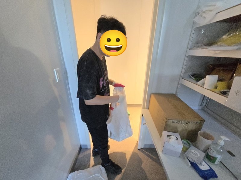 작업자가 사무실 선반 위 물품 정리 중