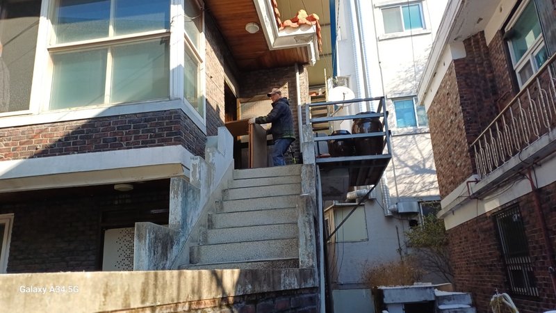 작업자가 가구 파편을 운반하고 있는 모습